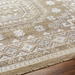 Surya Almeria hand-knotted low pile rug with mustard, gray, blue, beige, cream, and black geometric patterns.