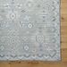 Hand-knotted Surya Almeria rug, low pile with light blue, white, and gray geometric patterns, fringe detail.