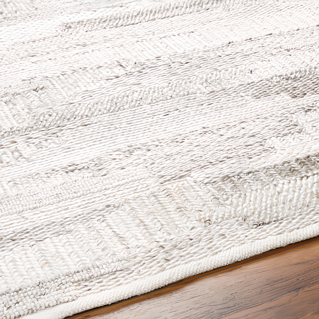 Hand-woven Surya Floria rug, light neutral recycled PET yarn with subtle striped texture on a wooden floor.