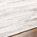 Hand-woven Surya Floria rug, light neutral recycled PET yarn with subtle striped texture on a wooden floor.