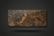 Brown marble slab with intricate white and dark brown veining on a dark gray background.