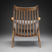 Rear view of a modern wooden accent chair with a slatted back and gray herringbone cushions.