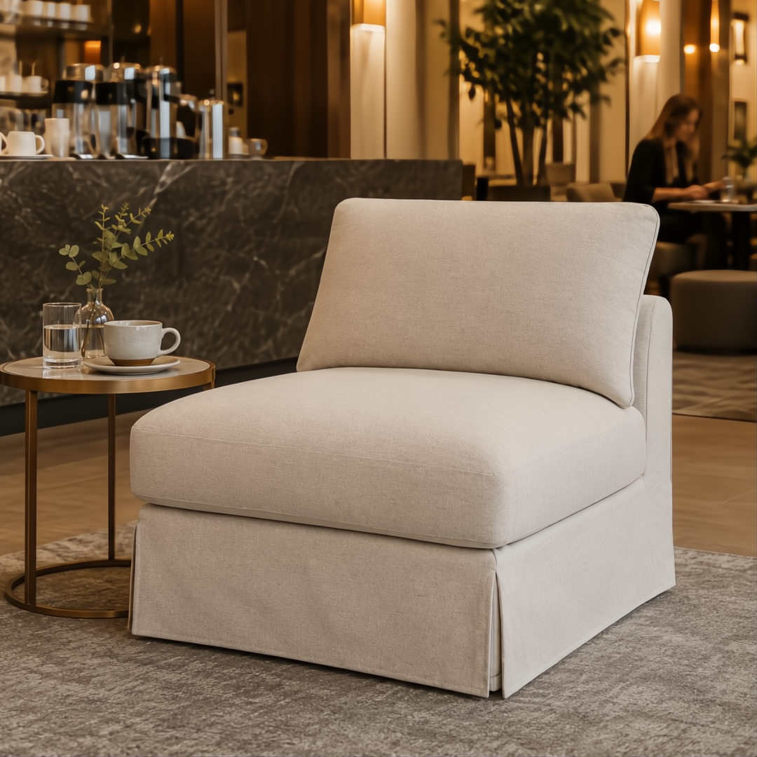 Taupe Surya Elenora modular chair with polyester upholstery and a simple, polished design, next to a small round table.