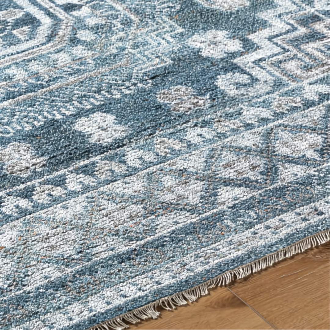Hand-knotted Surya Almeria low pile area rug in blue, gray, beige, and cream with fringe.