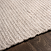 Surya Azalea AZA-2315 hand-woven rug in light beige recycled PET yarn on a dark wood floor.
