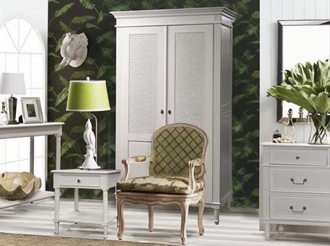 White Polo Side Table with single drawer and rattan shelf, next to a chair and wardrobe.