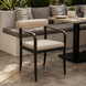 Surya Antibes dining chair with black aluminum frame and beige Sunbrella upholstery on a patio.