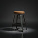 Surya Balin counter stool with brown polished leather top, black iron base, and spinning adjustable seat.