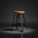 Surya Balin counter stool with brown polished leather top, black iron base, and spinning adjustable seat.