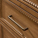 Close-up of a brown painted oak veneer dresser drawer with a dark bronze pull handle and beaded trim.