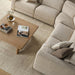 Beige polyester power reclining sectional with a light wood coffee table on a textured rug.