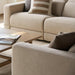 Beige polyester Surya Lloyd Power Sectional with brown pillows and a coffee table.
