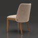 Surya Brooke dining chair with medium brown polyester upholstery, wheat-finished beechwood base, and decorative button.
