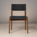 Surya Chia dining chair with brown stained ash wood frame and black woven seat and back.