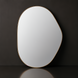 Modern organic-shaped wall mirror with a thin gold frame, reflecting light against a dark background.