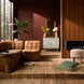 Surya Oryan modular sofa in brown leather, with a textured rug and modern decor in a living room.