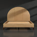 Surya Elipse upholstered bed with a rounded tan leather headboard and dark brown stained wooden legs.