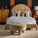 Surya Elipse Upholstered Bed with a tall, curved headboard in tan leather, dark brown base, and a matching ottoman.