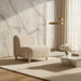 Off-white polyester accent chair with a brown rubber wood base in a modern living room.