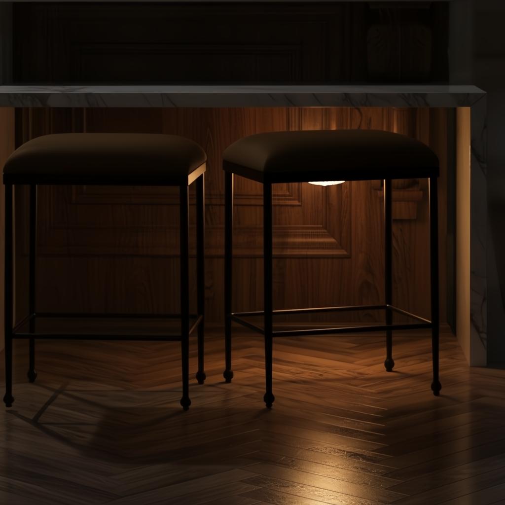 Two Surya Kornel counter stools with dark polyester seats and black powder-coated iron bases under a marble counter.