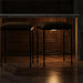 Two Surya Kornel counter stools with dark polyester seats and black powder-coated iron bases under a marble counter.