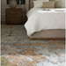 Brown Surya Covina upholstered bed with a beige headboard and white bedding, next to a wooden nightstand.