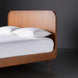 Brown stained poplar wood bed with a minimalist modern design and slatted headboard.