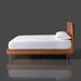 Surya Madri brown stained poplar wood bed with a minimalist modern design and white bedding.