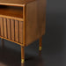 Brown Madri nightstand with a minimalist modern design, poplar top, fluted drawer, and brass-capped legs.