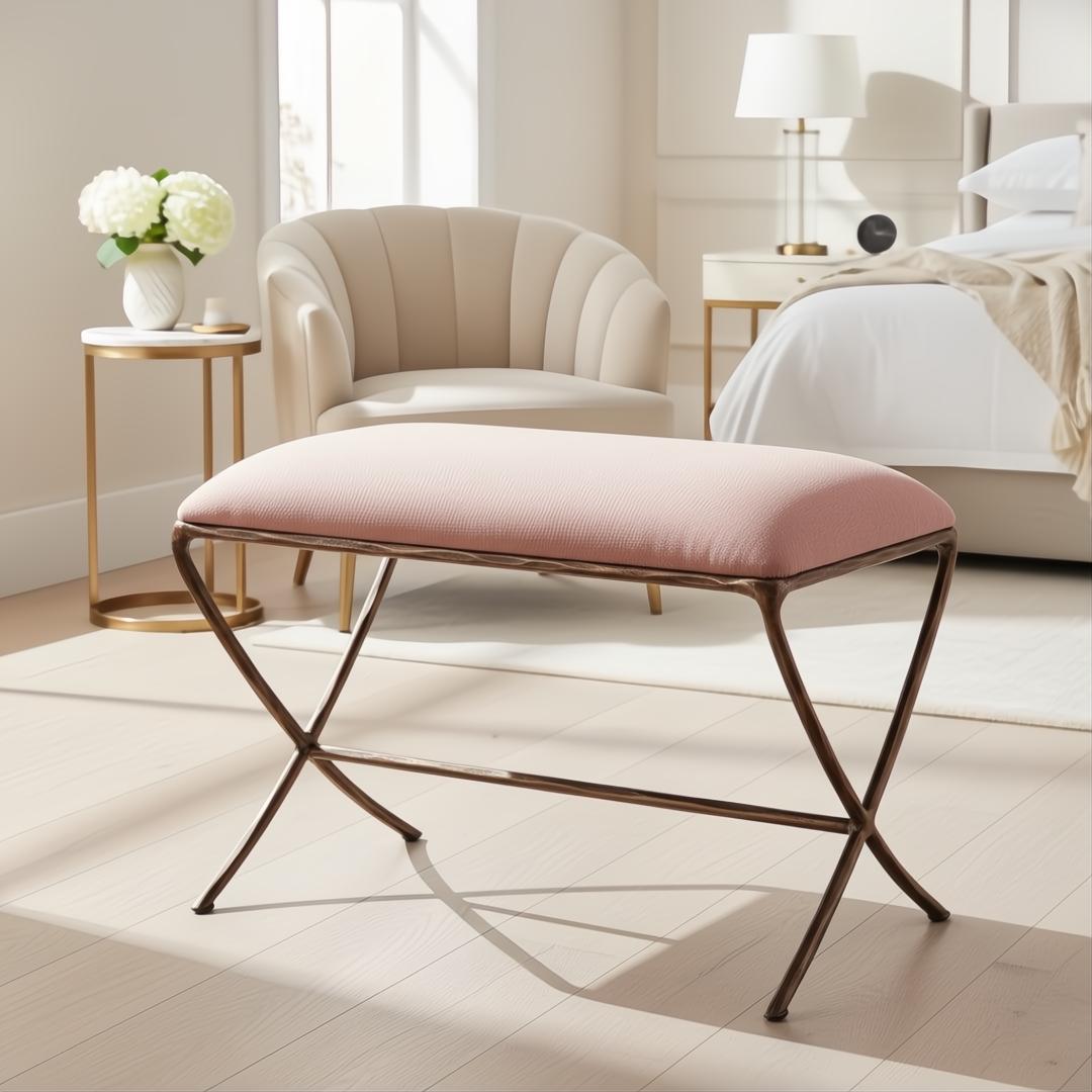 Surya Misho ottoman with a metallic copper X-frame base and a blush pink polyester cushion.