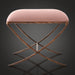 Surya Misho ottoman with a metallic copper finish X-frame base and a plush, rounded pink polyester cushion.