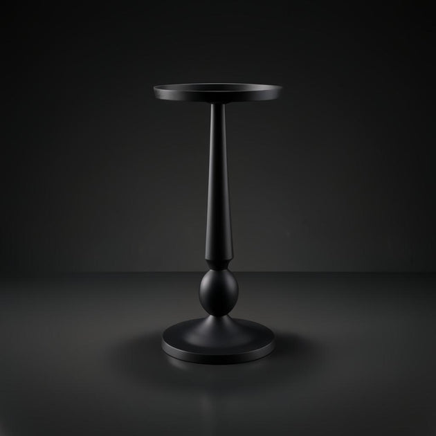 Black aluminum Surya Molino end table with a round top, slender pedestal, and circular base.