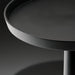 Close-up of a black aluminum Surya Molino end table with a round top and pedestal base.