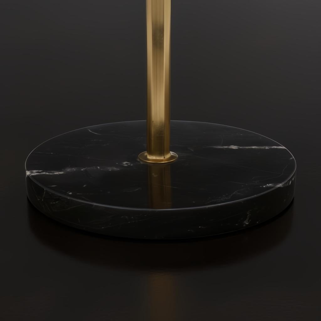 Close-up of a round black natural marble base with white veining and a brass-colored stand.