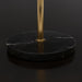 Close-up of a round black natural marble base with white veining and a brass-colored stand.