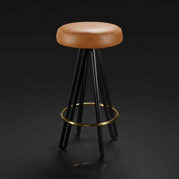 Surya Oberon backless bar stool with brown leather seat, black steel base, and brass footrest.