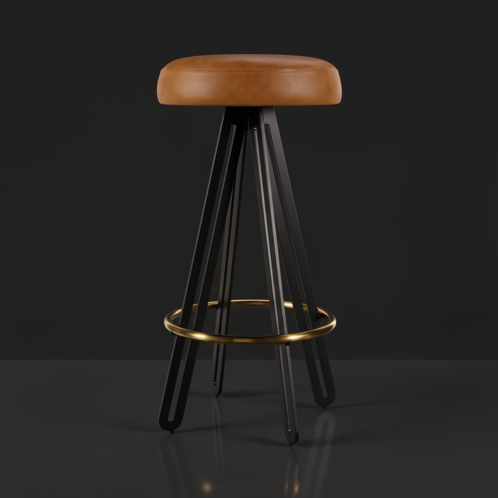 Surya Oberon backless bar stool with brown leather seat, black steel base, and gold footrest.