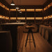 Surya Oberon bar stool with brown leather seat and black steel base in a cozy wine cellar.