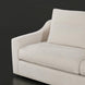 Close-up of a light beige fabric sofa with a curved armrest and a rectangular throw pillow.
