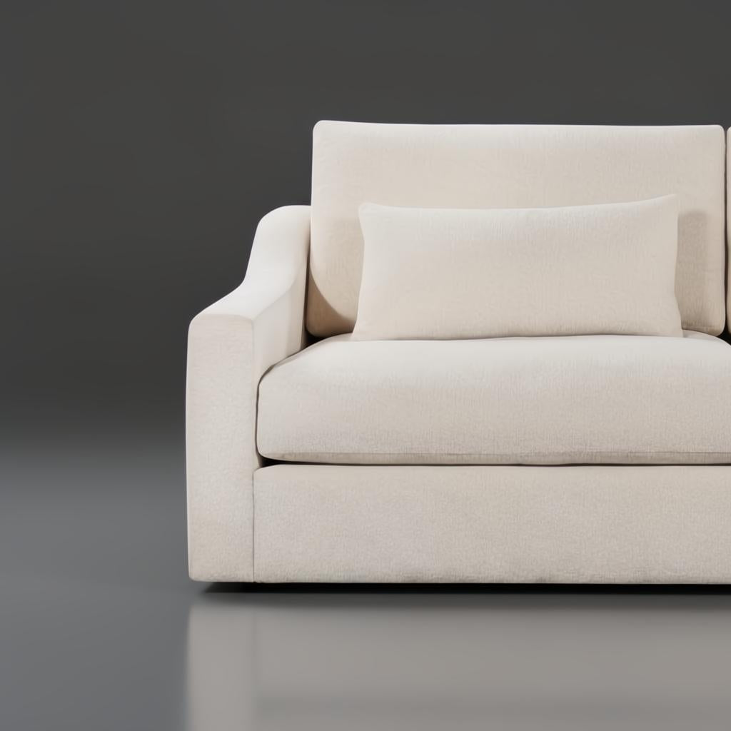 Close-up of a light beige polyester sectional sofa with a matching lumbar pillow.