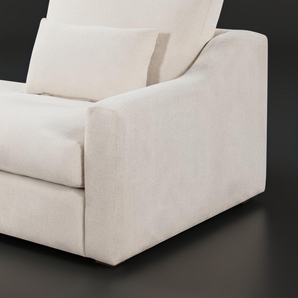 Close-up of a light beige polyester sectional sofa with a wide armrest and a matching throw pillow.