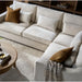 Surya Pedersen Left Arm Facing Sectional in light brown polyester with accent pillows and a wooden coffee table.