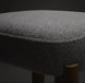 Close-up of a Surya Pico Dining Chair seat, showing taupe polyester and linen fabric upholstery with a textured weave and a glimpse of the brown rubber wood base.