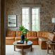 Surya Oryan modular sofa in brown leather, with a round wooden coffee table and accent table.