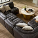 Black leather Surya Oryan modular sofa with tufted cushions and pine base, arranged in a living room.