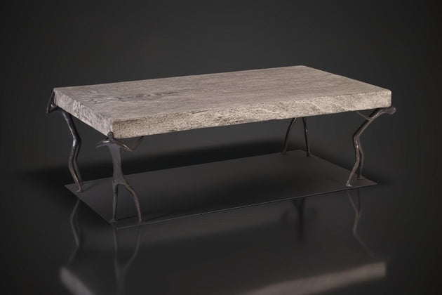 Gray Atlas Coffee Table with a textured stone top and dark metal human-figure legs on a base.